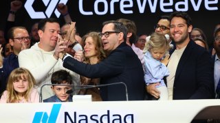 CoreWeave founders Brian Venturo, at left in sweatshirt, and Mike Intrator slap five after ringing the opening bell at Nasdaq headquarters in New York on March 28, 2025.