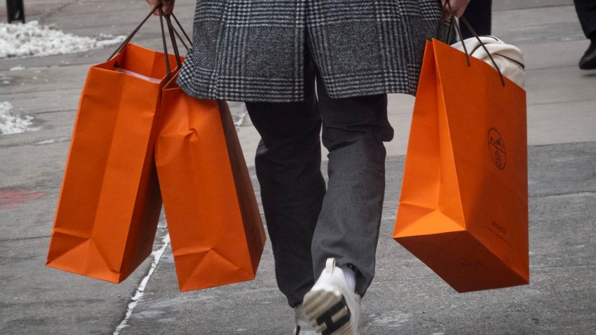 A customer carries merchandise from a Hermes store on Feb. 14, 2025.