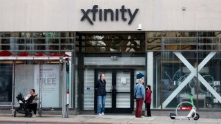 Customers enter an Xfinity Store by Comcast on February 24, 2025 in San Francisco, California. (Photo by Justin Sullivan/Getty Images)
