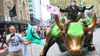 Climate activists hold a protest at the Charging Bull statue in Bowling Green near the New York Stock Exchange on April 22, 2025.