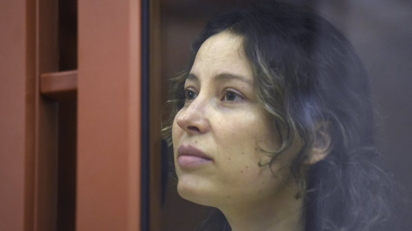 FILE – Ksenia Karelina, also known as Khavana sits in a glass cage in a court room in Yekaterinburg, Russia, Thursday, Aug. 15, 2024.