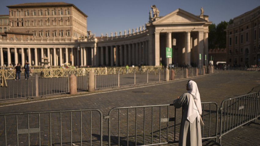A nun leans on railings in St. Peter's Square at the Vatican