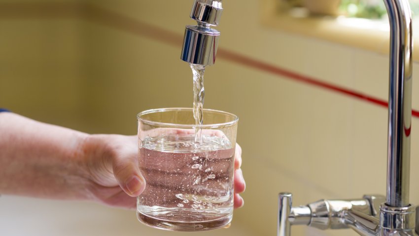 Pouring a glass of water from a kitchen faucet