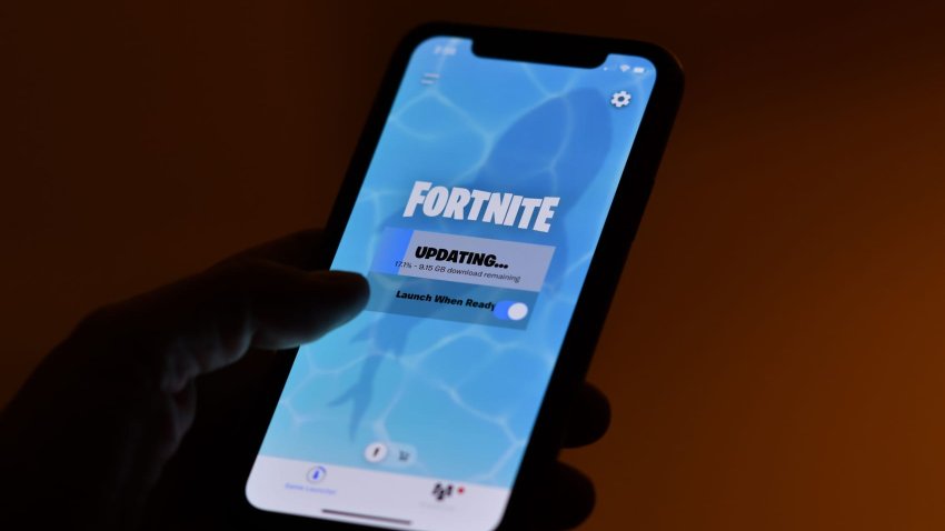 This illustration picture shows a person waiting for an update of Epic Games’ Fortnite on their smartphone in Los Angeles on August 14, 2020.