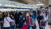 People wait in line for a delayed flight at Newark International Airport on May 5, 2025 in Newark, New Jersey.