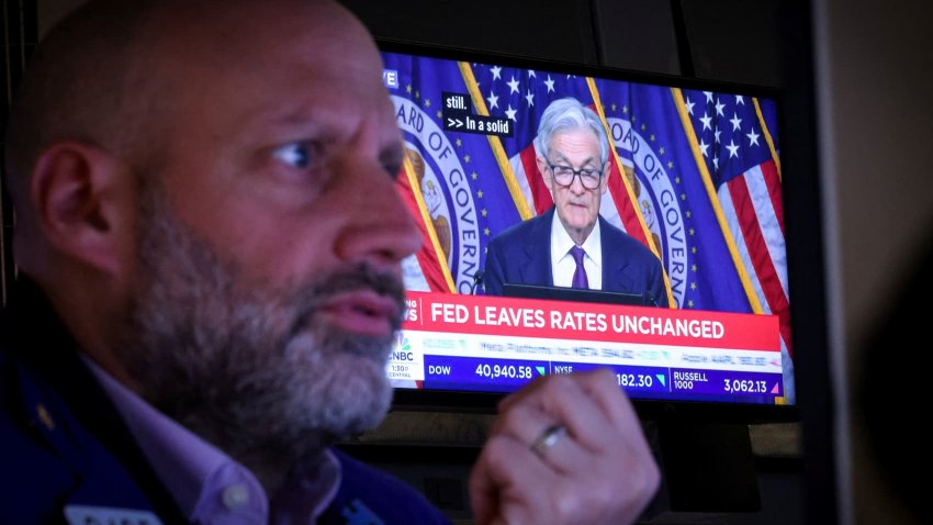 A trader works, as a screen broadcasts a news conference by U.S. Federal Reserve Chair Jerome Powell following the Fed rate announcement, on the floor of the New York Stock Exchange (NYSE) in New York City, U.S., May 7, 2025.