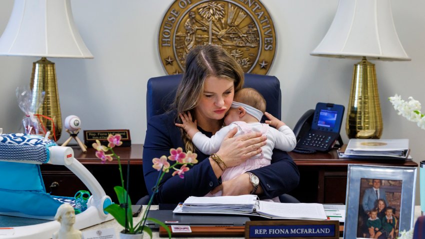 Florida Rep. Fiona McFarland, R-Sarasota, holds her 7-month-old daughter Grace Melton while working at her desk, Thursday, April 17, 2025, in Tallahassee, Fla. (AP Photo/Colin Hackley)