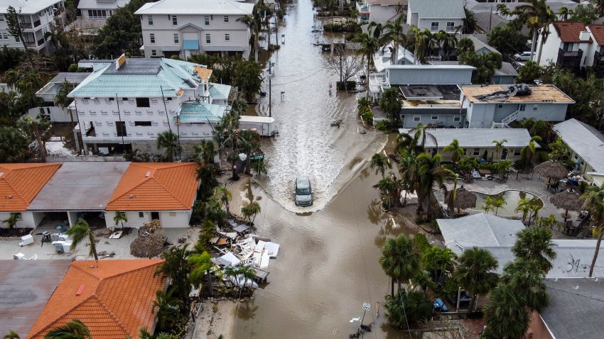 TOPSHOT – In this aerial photo, a vehicle drives though a flooded street after Hurricane Milton, in Siesta Key, Florida, on October 10, 2024. At least 10 people were dead after Hurricane Milton smashed into Florida, US authorities said October 10, 2024, after the monster weather system sent tornados spinning across the state and flooded swaths of the Tampa Bay area. (Photo by CHANDAN KHANNA / AFP) (Photo by CHANDAN KHANNA/AFP via Getty Images)
