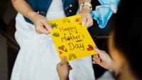 Close-up of woman receiving greeting card from her son on Mother's day.