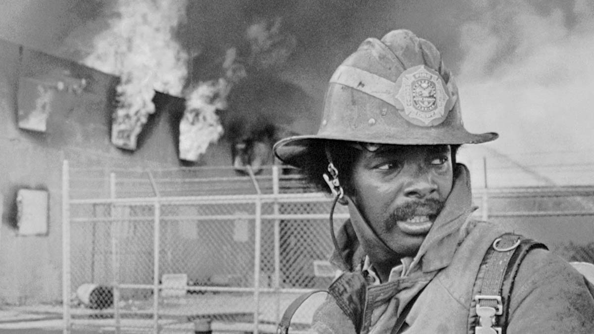 (Original Caption) Firemen have been helpless in trying to extinguish all the fires that have started in Miami following the beginning of racial disorder there. Looking back over his shoulder, a city fire fighter prepares to fight yet another blaze in the riot area.