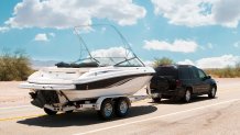 An suv towing a boat heads down the road