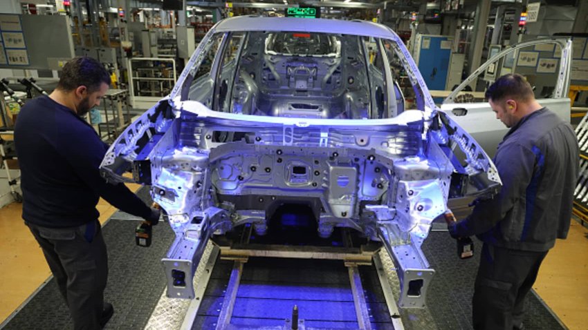 Workers assemble cars on the assembly line at the Volkswagen automobile factory on March 07, 2025 in Wolfsburg, Germany.