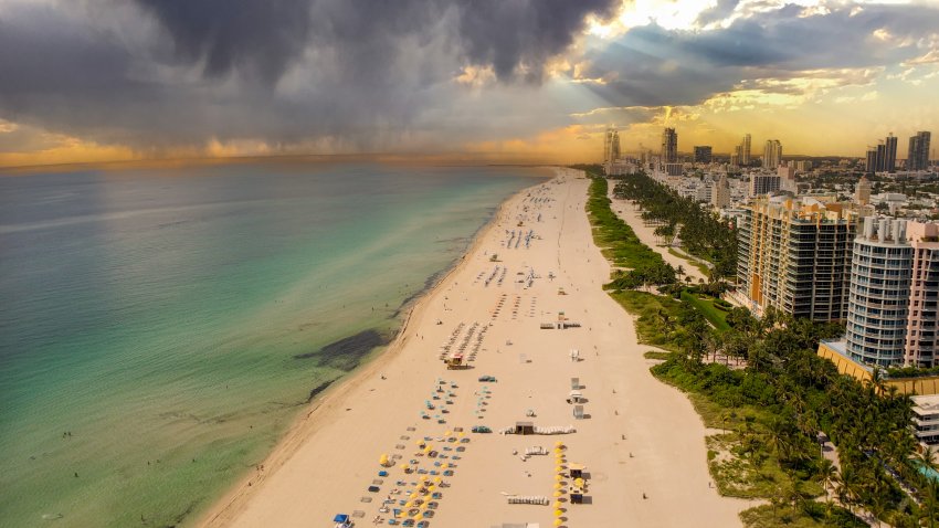 Miami Beach, Florida, USA – June 24, 2022:  Aerial view of a Miami Beach with storm clouds and the Miami Skyline in the background.