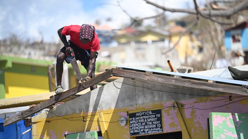 A man saws a piece of wood to repair the roof of a shop in Westmoreland, Jamaica, following the passage of Hurricane Melissa, on November 2, 2025. Planes and helicopters carrying humanitarian aid headed to Jamaica on October 31, three days after Melissa slammed into the island nation and killed at least 19 people.
Information Minister Dana Morris Dixon told a briefing that authorities had “quite credible” reports of possibly five additional deaths but had not yet been able to confirm. (Photo by Ricardo Makyn / AFP) (Photo by RICARDO MAKYN/AFP via Getty Images)