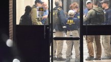 PROVIDENCE, RHODE ISLAND - DECEMBER 13: Members of the FBI Evidence Response Team work at the scene near a body, collect evidence and mark the area with evidence markers at Brown University in Providence, R.I., Saturday, Dec. 13, 2025, during a mass shooting that at least killed two people and wounded eight others. (Photo by Kyle Mazza/Anadolu via Getty Images)
