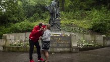 TOPSHOT - A couple kisses under the statue of a famous Czech romantic poet Karel Hynek Macha as a part of a Czech May Day tradition at Petrin Hill on May 1, 2020 in Prague. (Photo by Michal Cizek / AFP) (Photo by MICHAL CIZEK/AFP via Getty Images)