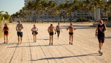 MIAMI BEACH, FLORIDA - MARCH 23: Robert "Raven" Kraft is joined by other runners on the back beach in Lummus Park on March 23, 2020 in Miami Beach, Florida. Kraft, who has run every day on Miami Beach since January 1, 1975, continues to run eight miles daily despite the dangers that the COIVD-19 epidemic presents.  (Photo by Cliff Hawkins/Getty Images)
