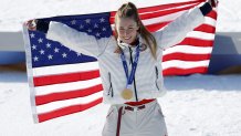Mikaela Shiffrin posing with American flag and gold medal