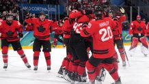 Mitch Marner of Canada celebrates with teammates after scoring their fourth goal in overtime to win the men's hockey quarterfinal against Czechia.